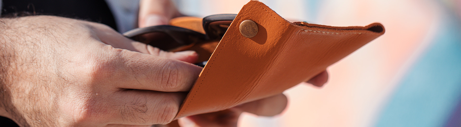 putting-sunglasses-into-yellow-leather-case v1